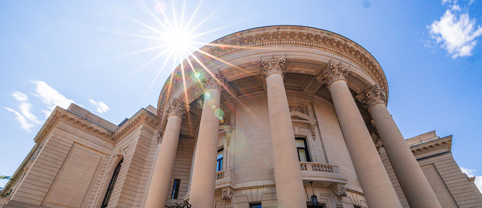 Yale campus building with columns against a sunny blue sky