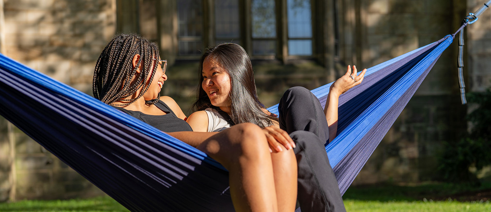 two students laying together in a sunny hammock