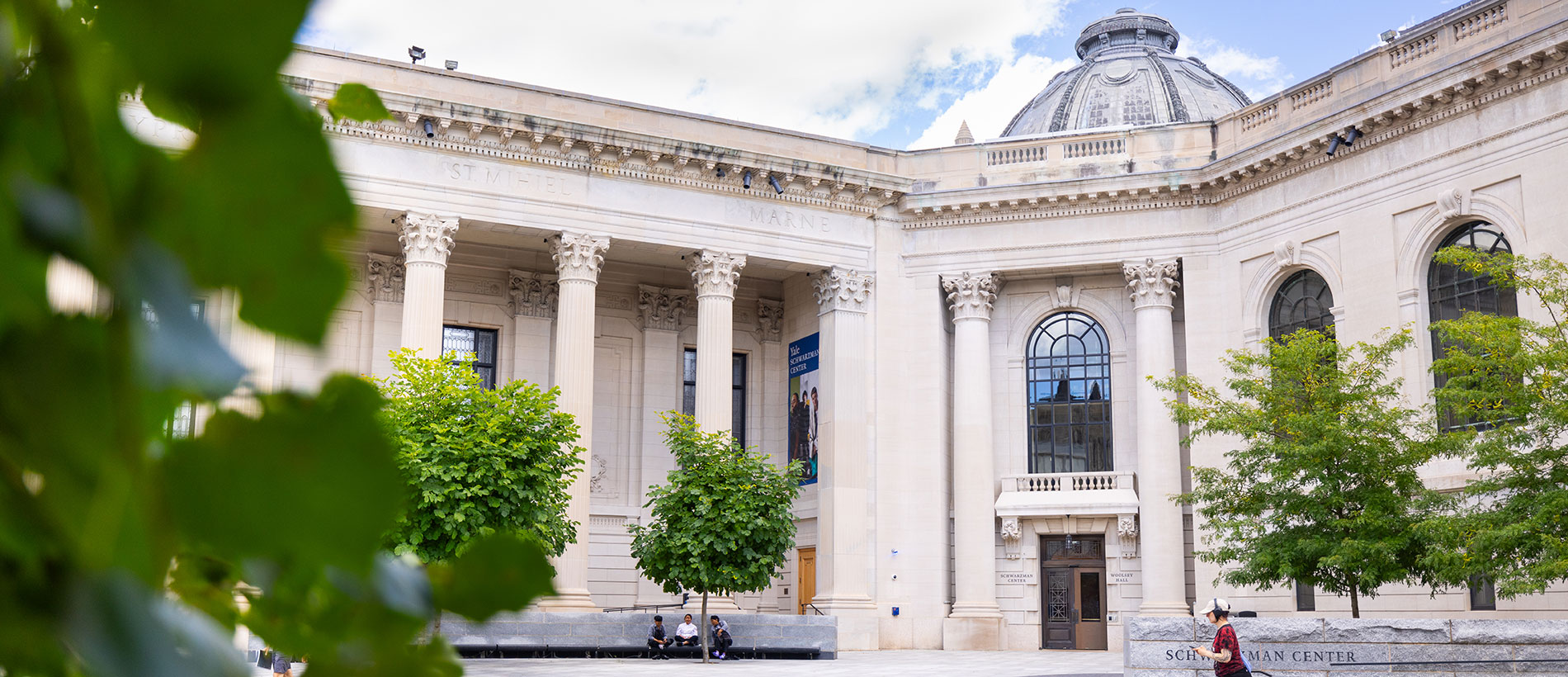 white building with regal columns and leafy green trees