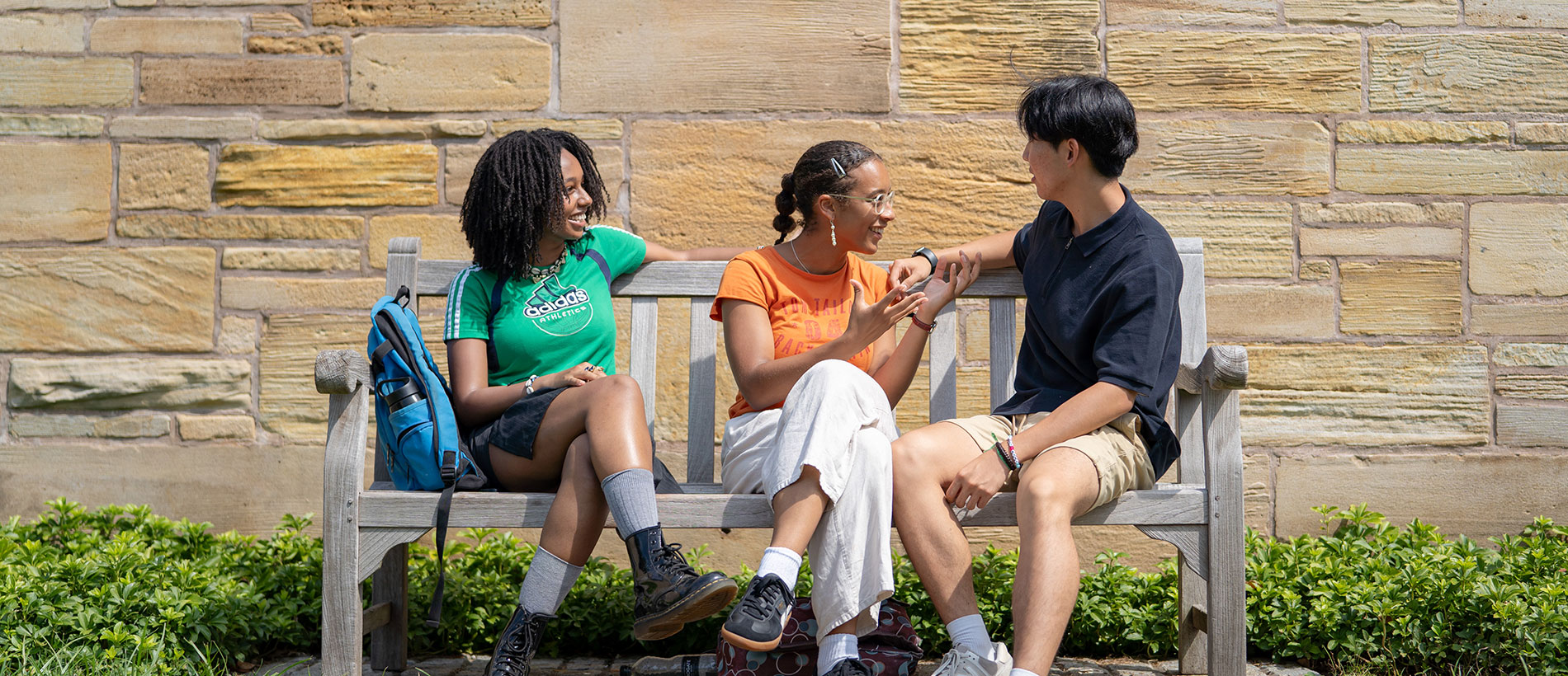 students on a bench chatting with each other